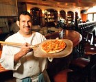 Seafood and More: Eladio Chavez cooks up a pizza in the brand-new wood-fired oven at Steamer's. Photo by George Sakkestad
